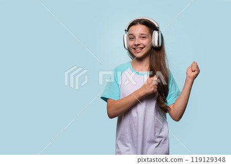 Girl smiling while dancing and enjoying music with headphones. Girl smiling while dancing and enjoying music with headphones. 119129348