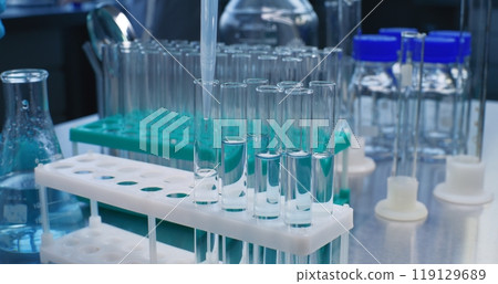 Scientist in medical laboratory fills test tubes with liquid of developed sample 119129689