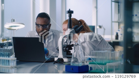 Diverse team of two scientists working on creating new drugs 119129769