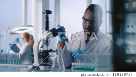 Scientists in white coats work in advanced laboratory Scientists in white coats work in advanced laboratory 119129785