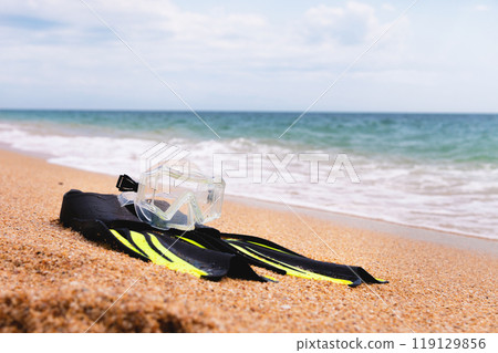 On the golden sea beach lie a snorkel mask and fins. Concept of snorkeling at sea 119129856