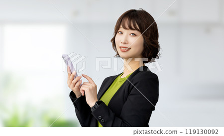 使用智慧型手機的微笑的女商人 使用智慧型手機的微笑的女商人 119130092