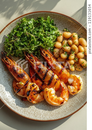 Grilled shrimp served over white beans with herbs on a rustic plate in natural light Grilled shrimp served over white beans with herbs on a rustic plate in natural light 119131654