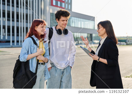 Woman agent teacher social worker working with college students using digital tablet outdoor Woman agent teacher social worker working with college students using digital tablet outdoor 119132107