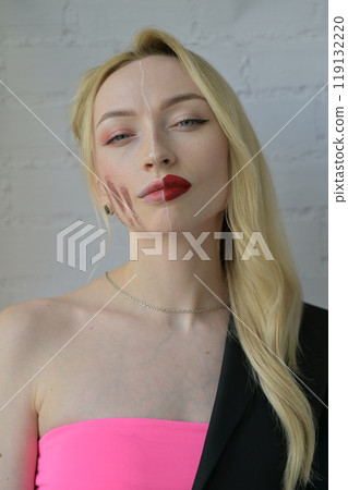 Close-up portrait of a blonde girl look at camera with different make-up on half of her face on white background Close-up portrait of a blonde girl look at camera with different make-up on half of her face on white background 119132220
