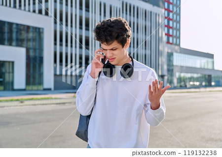Young serious guy talking on mobile phone, modern city background, urban style Young serious guy talking on mobile phone, modern city background, urban style 119132238