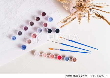 Brushes, multi-colored acrylic paints and canvas for painting by numbers  top view 119132808