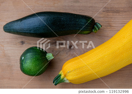 Yellow and green zucchinis, round green zucchini on the wood background. Yellow and green zucchinis, round green zucchini on the wood background. 119132996
