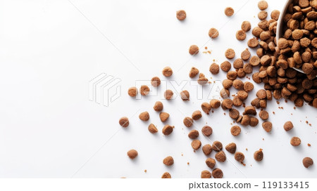 Dry cat food is scattered across a clean white surface, showcasing its texture and shape, providing an appealing option for pet owners looking to feed their kittens Dry cat food is scattered across a clean white surface, showcasing its texture and shape, providing an appealing option for pet owners looking to feed their kittens 119133415