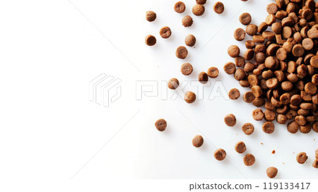 A variety of dry cat food kibble is scattered on a clean white surface, highlighting its crunchy texture and appealing brown color, ideal for nourishing cats A variety of dry cat food kibble is scattered on a clean white surface, highlighting its crunchy texture and appealing brown color, ideal for nourishing cats 119133417