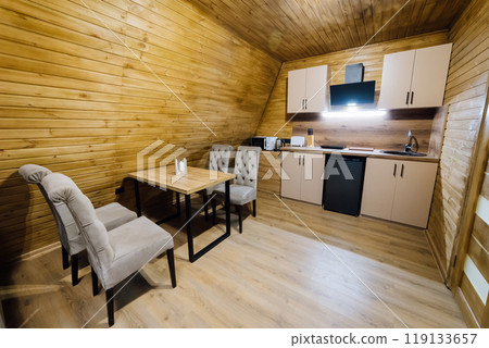 Modern wooden cabin interior with kitchen and loft area, perfect for relaxation and cozy retreats 119133657