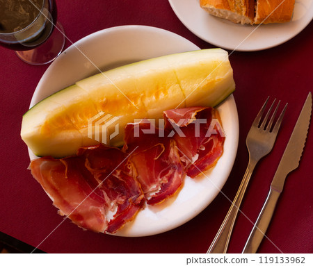 Mediterranian appetizers melon with ham on white plate. 119133962
