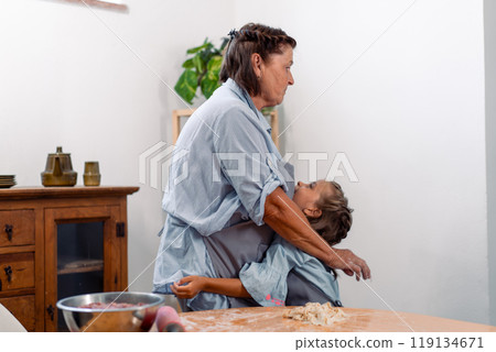 Affectionate grandmother embraces granddaughter Affectionate grandmother embraces granddaughter 119134671