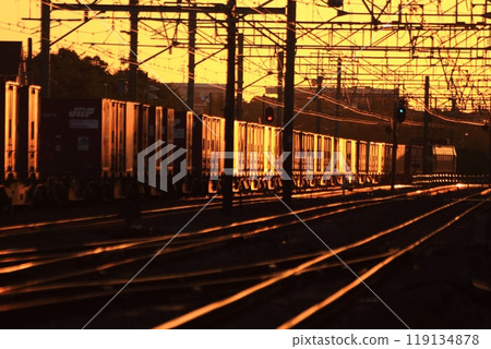 一列貨運列車在橘色的日出中行駛 119134878