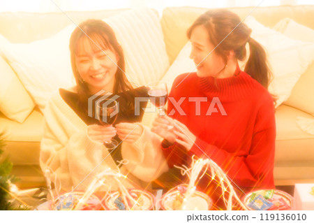 Two women toasting Christmas with wine Two women toasting Christmas with wine 119136010