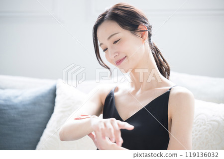Beautiful woman applying cream to treat rough and dry hands in winter. Close-up image of hands 119136032