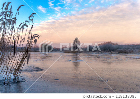 Serene Winter Lakeside Scene with Icy Reflections at Sunset 119138385