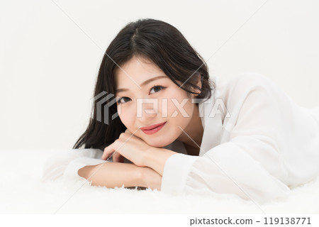Beauty image: A young woman lying down in a white shirt 119138771