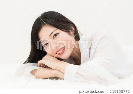 Beauty image: A young woman lying down in a white shirt 119138772