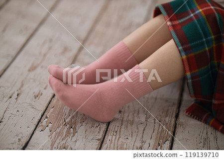 The feet of a young woman putting on socks 119139710