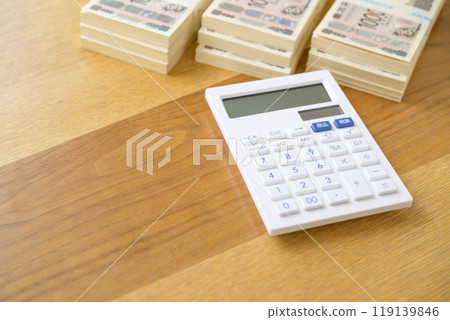 A stack of bills and a calculator on a desk (new bill version) A stack of bills and a calculator on a desk (new bill version) 119139846