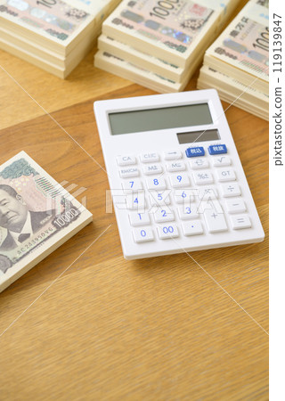 A stack of bills and a calculator on a desk (new bill version) 119139847