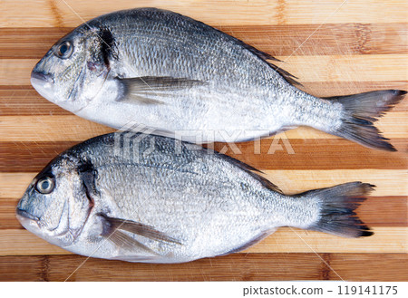 two fresh sea bream on a cutting board two fresh sea bream on a cutting board 119141175