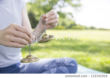 Woman's hands using Tingsha in outdoor yoga Outdoor yoga image Woman's hands using Tingsha in outdoor yoga Outdoor yoga image 119142928