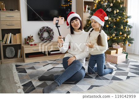 Mom and daughter video call in front of Christmas tree Mom and daughter video call in front of Christmas tree 119142959