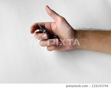Hand holding black polyhedral dice for tabletop gaming on white background Hand holding black polyhedral dice for tabletop gaming on white background 119143744