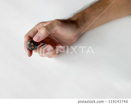 Hand holding twenty-sided dice for role-playing games on white background 119143748