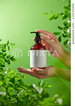 The model's hands are stationary and gripping the pump bottle without a label. The naturalness of the goods is enhanced by the woodland background, which is full of verdant trees and golden sunlight. The model's hands are stationary and gripping the pump bottle without a label. The naturalness of the goods is enhanced by the woodland background, which is full of verdant trees and golden sunlight. 119143848
