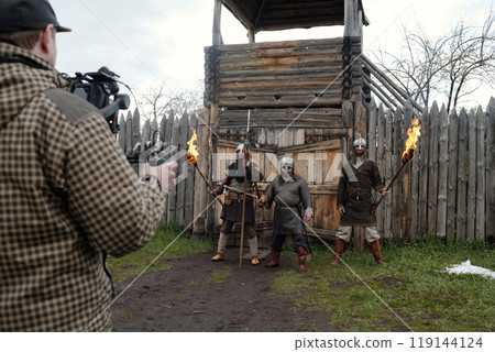 Filming Medieval Warriors at Wooden Fort with Torches Filming Medieval Warriors at Wooden Fort with Torches 119144124