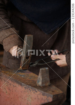 Person Forging Metal with Hammer and Anvil Person Forging Metal with Hammer and Anvil 119144206