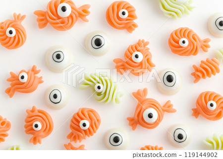 Assortment of candy eyeballs and swirled decorations on white background. Halloween fun and creativity Assortment of candy eyeballs and swirled decorations on white background. Halloween fun and creativity 119144902