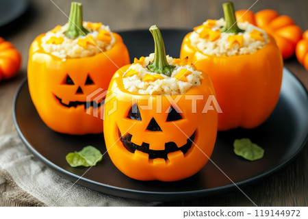 Stuffed orange bell peppers carved with jack-o'-lantern faces, filled with savory mixture. Halloween food concept 119144972