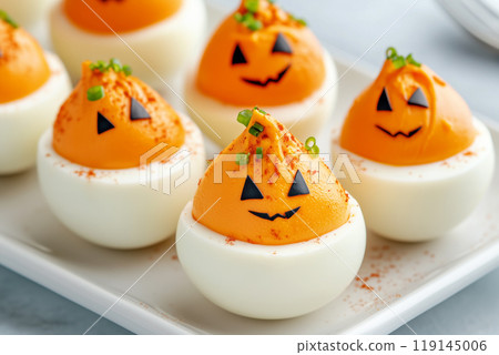 Closeup of deviled eggs garnished with herbs and paprika on white background. Concept of appetizers and holiday food 119145006