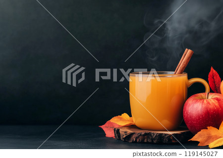 Warm beverage in mug with cinnamon sticks and colorful autumn leaves on a wooden surface. Autumn and cozy concepts 119145027