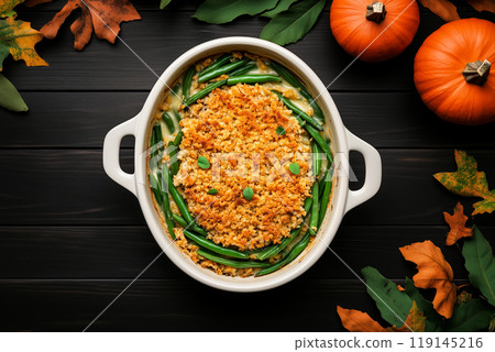 Green bean casserole topped with crispy onions in ceramic dish on wooden background. Thanksgiving Day side dishes 119145216