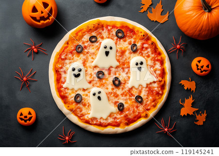 Cheese pizza on dark background surrounded by carved pumpkins and skulls representing Halloween theme with autumn leaves 119145241