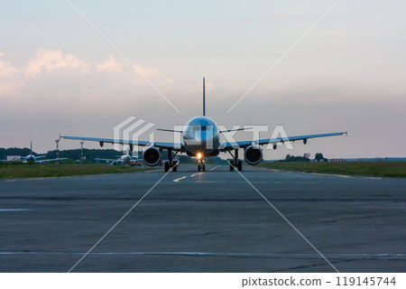 Taxiing passenger airplane early in the morning on the main taxiway Taxiing passenger airplane early in the morning on the main taxiway 119145744