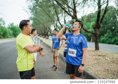 asian runners taking break and drinking water 119147998