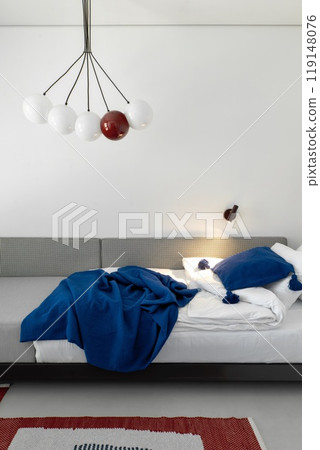 This modern bedroom features stylish decor elements and unique lighting for an inviting atmosphere This modern bedroom features stylish decor elements and unique lighting for an inviting atmosphere 119148076