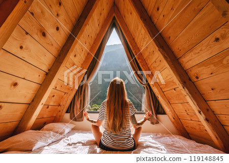 Woman Doing Yoga in Bed in a Frame Cabin Woman Doing Yoga in Bed in a Frame Cabin 119148845