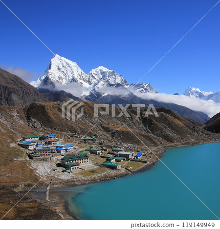 Lodges in Gokyo, turquoise lake and snow covered mountain Cholatse on a autumn day, Nepal. 119149949