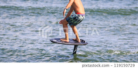 Man riding on a kite board hydrofoiling in the Atlantic Ocean 119150729