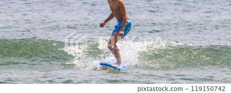 Surfer riding on a small wave in the ocean Surfer riding on a small wave in the ocean 119150742
