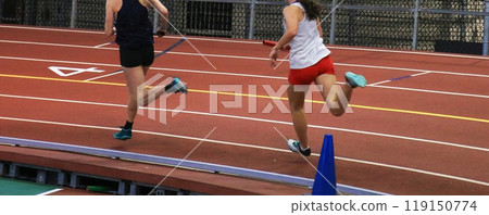 wo runners running in an indorr track race on a banked track wo runners running in an indorr track race on a banked track 119150774