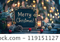 Festive chalkboard and Christmas decorations, lighting garland, candles, pine cone near Christmas tree. Text - Merry Christmas! Xmas card. 119151127