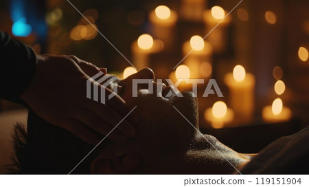 Serene head massage in dimly lit room, Tranquil hands-on therapy with candles and soft music for client relaxation Serene head massage in dimly lit room, Tranquil hands-on therapy with candles and soft music for client relaxation 119151904